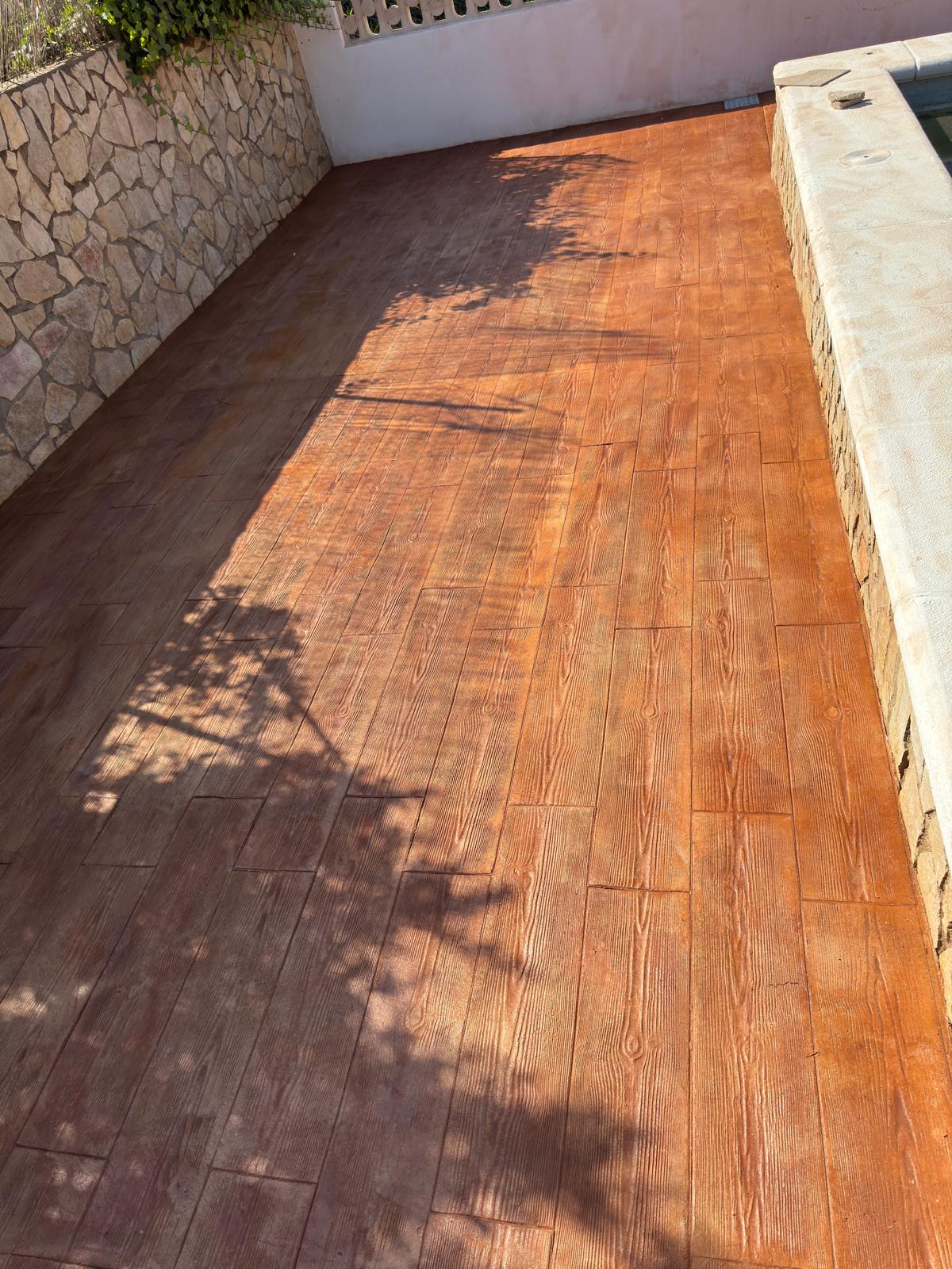 Terraza de piscina con hormigón impreso imitación madera